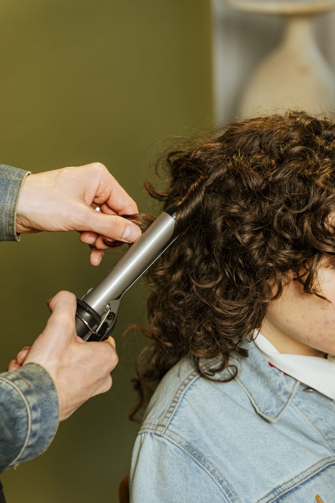 Coiffeuse réalisant un coiffage express lors d'un événement d'entreprise