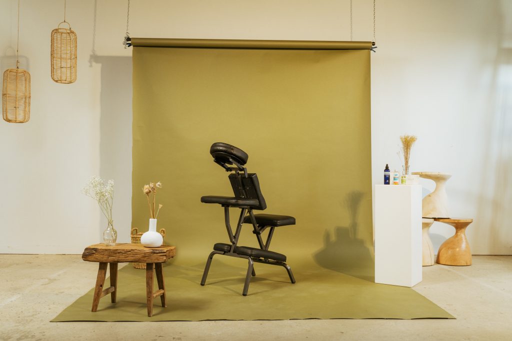 Animation bien-être en entreprise : siège de massage assis installé sur fond olive